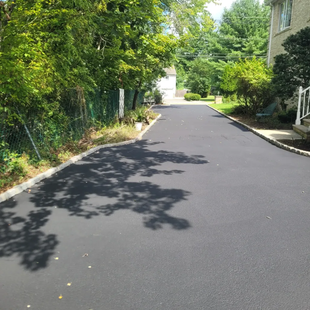 Driveway resurfacing in New Jersey — newly paved tree-lined drive
